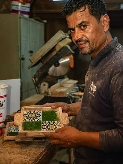 An ArtisRaw artisan carving an olive wood spoon