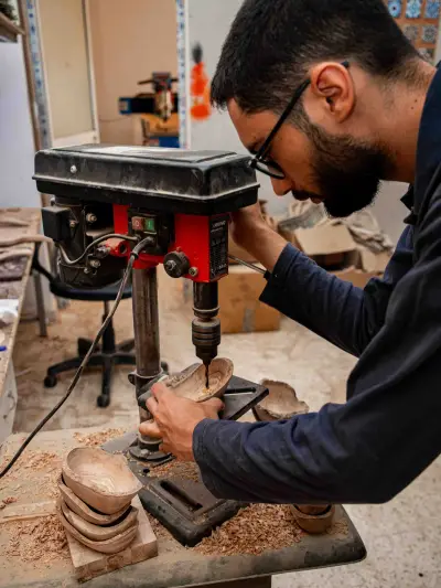 An ArtisRaw artisan finishing an olive wood board