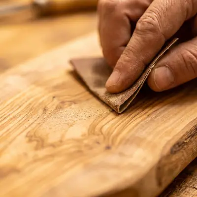 An olive wood piece being sanded by hand