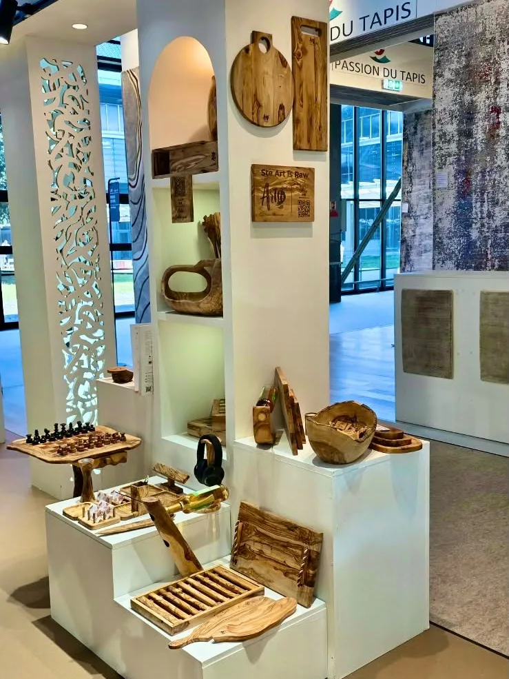 The ArtisRaw stand at Maison&Objet Paris 2026, with olive wood boards on the wall, a live-edge chess table and display plinths inside the Artisanat de Tunisie pavilion