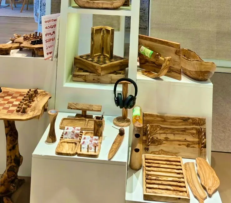 An olive wood headphone stand, a compartment desk tray and a folding games board on the ArtisRaw stand at Maison&Objet Paris 2026