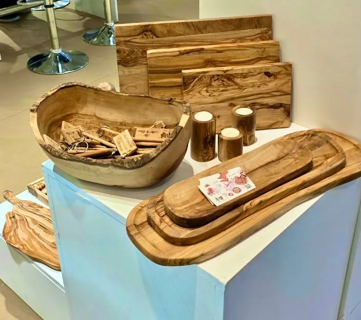 A live-edge olive wood serving bowl, nested oval serving trays and cutting boards on the ArtisRaw stand at Maison&Objet Paris 2026
